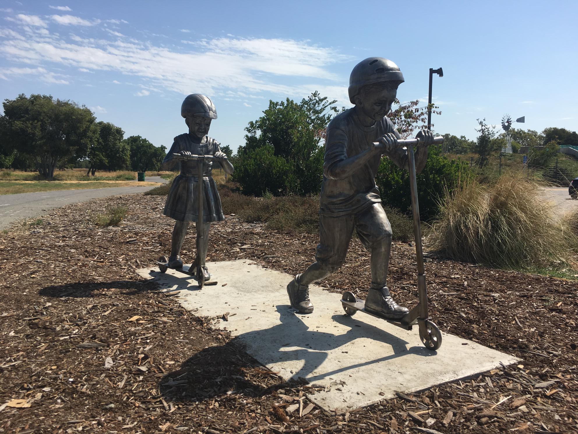 Children's Rotary Sculpture Walk Statues - Children on Scooters